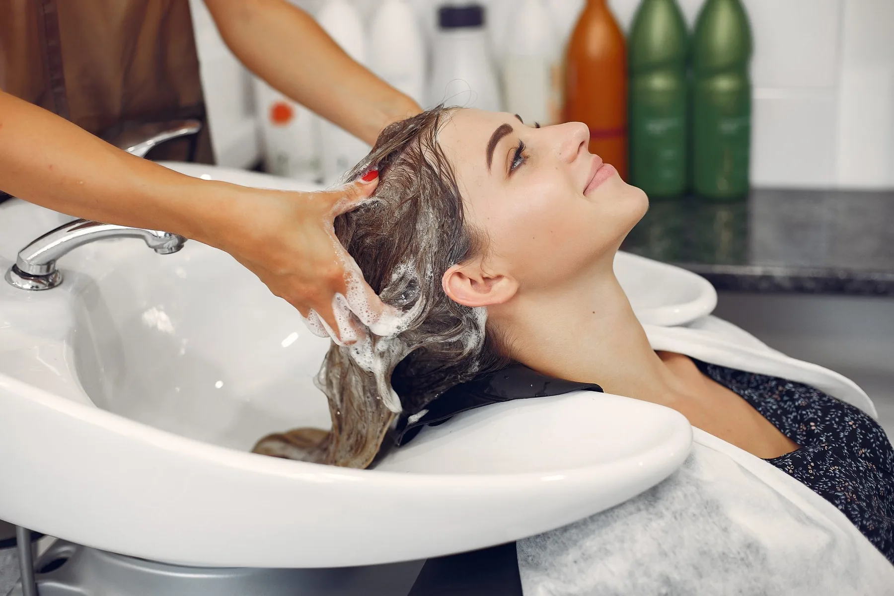 A client having their hair washed at a salon basin